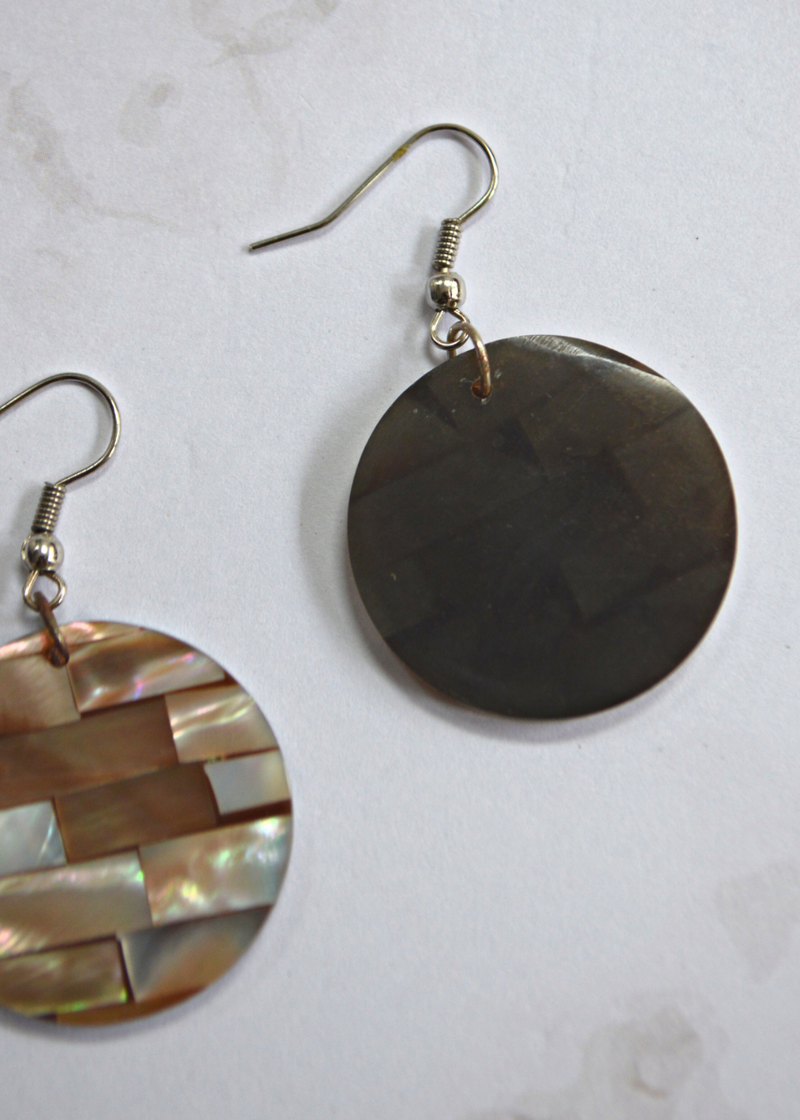 close up of the front and back of light brown Mother of Pearl Disc Earrings laid on a marble textured background