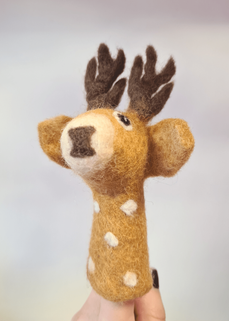 tan brown felt finger puppet with white spots and dark brown antlers and nose sat on someones finger