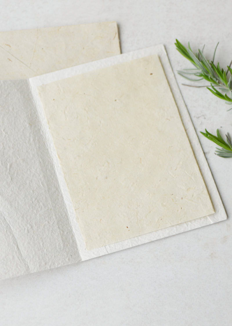 an open lokta paper greetings card laid next to an envelope