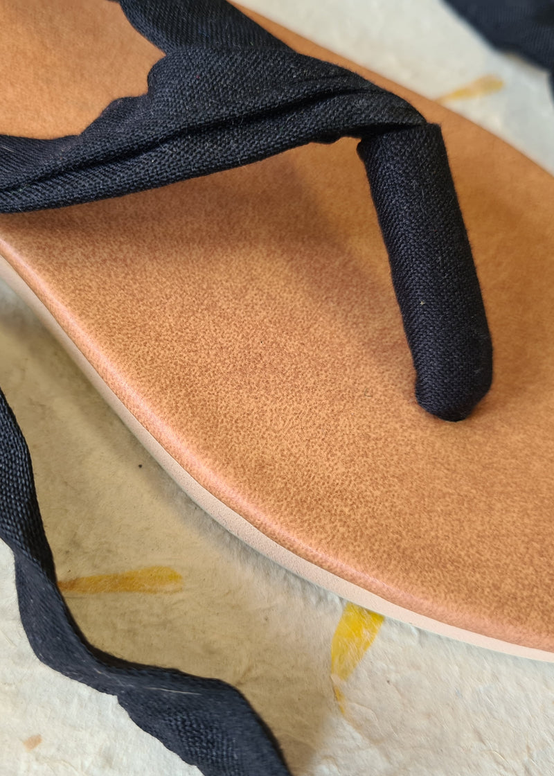 close up of handmade black lace up sandal cotton blend material and vegan leather sole