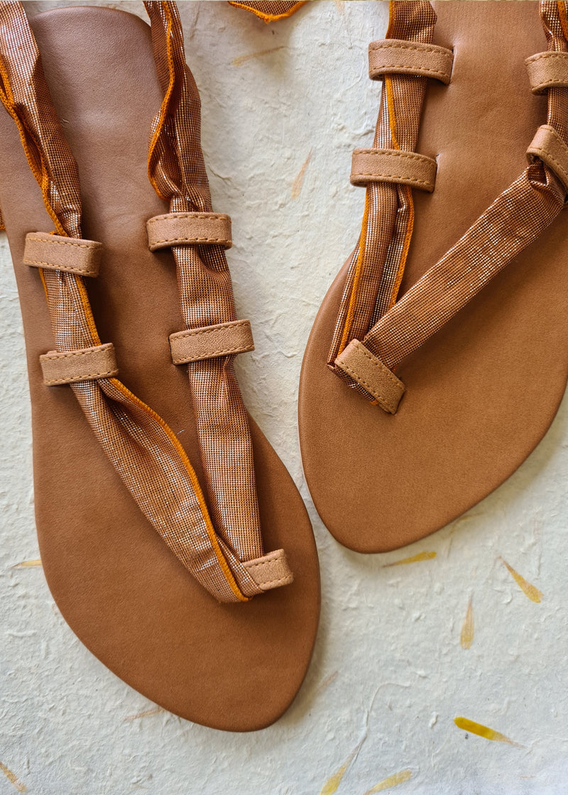 pair of brown metallic lace up sandals
