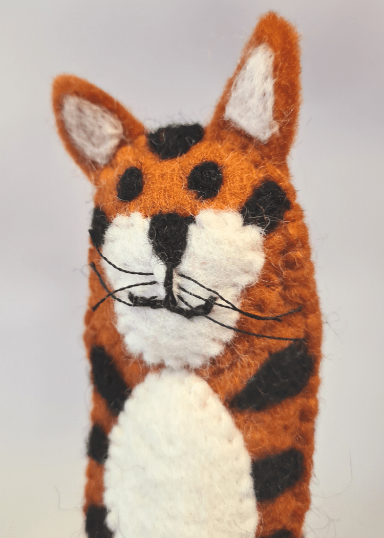 close up of Elefair Giftware kids handmade ethical toy, orange and black tiger felt finger puppet with white belly, ears and face, handmade in nepal