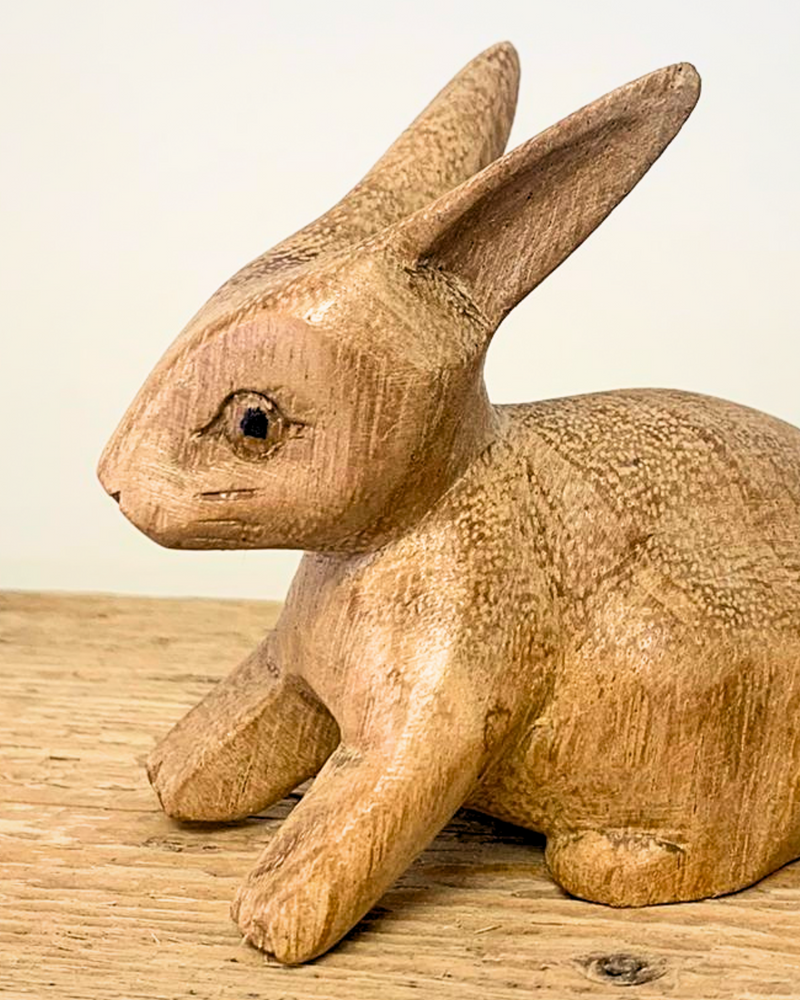 close up of carved wooden rabbit ornament sat on a wooden surface