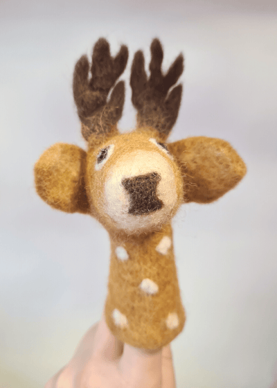 tan brown felt finger puppet with white spots and dark brown antlers and nose sat on someones finger