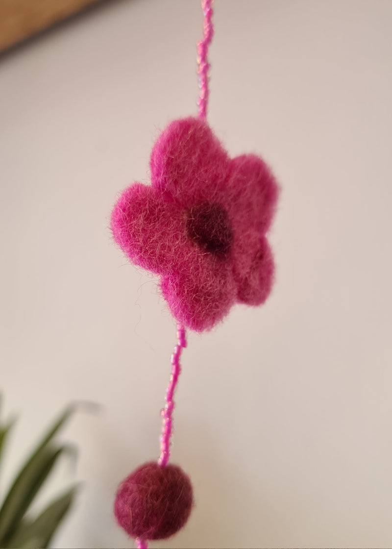 close up of flower on a Pink pom pom flower necklace with beads
