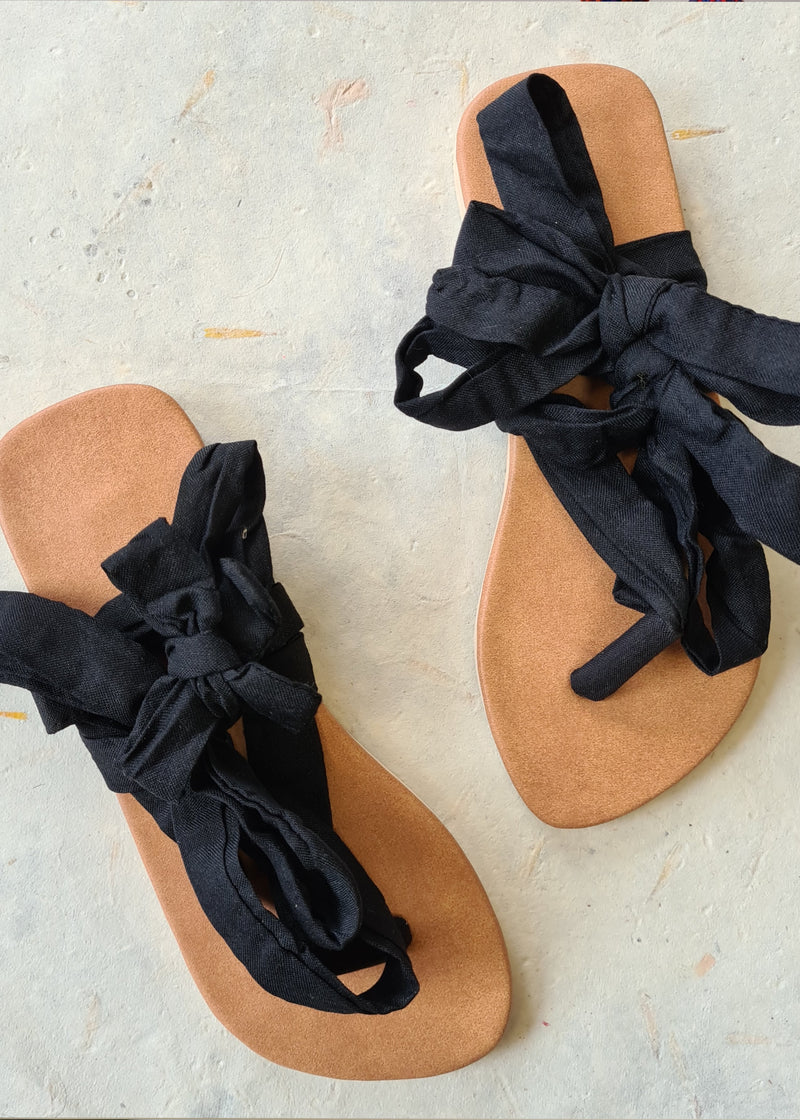 two handmade black lace up sandals tied into bows