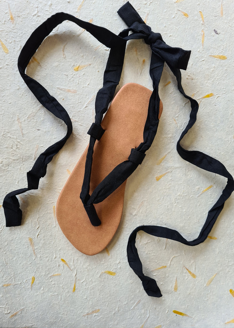 handmade black lace up sandal tied into a bow at the back and straps floating loose
