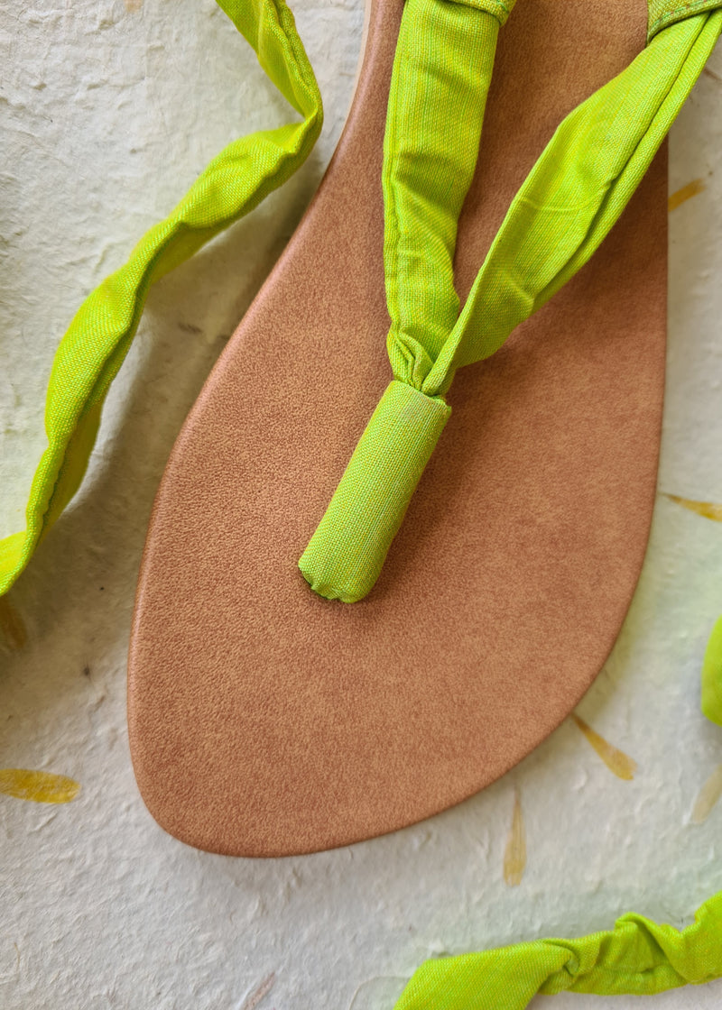 close up of untied handmade lime green lace up sandal
